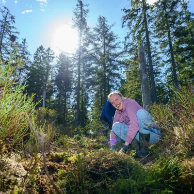 Lächelnder Teilnehmer hockt im Moor