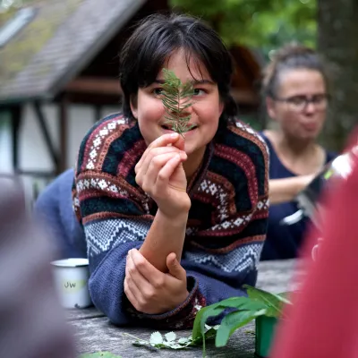 Junge Teilnehmerin hält ein Ästchen hoch