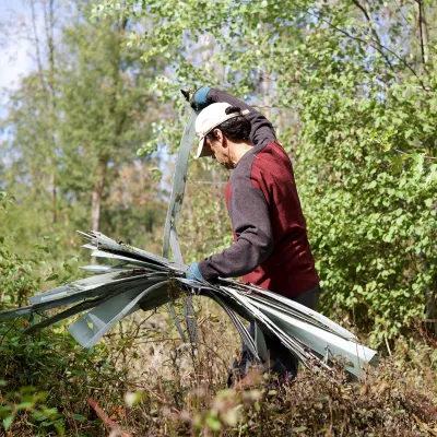 Teilnehmer sammelt Plastikreste im Wald auf