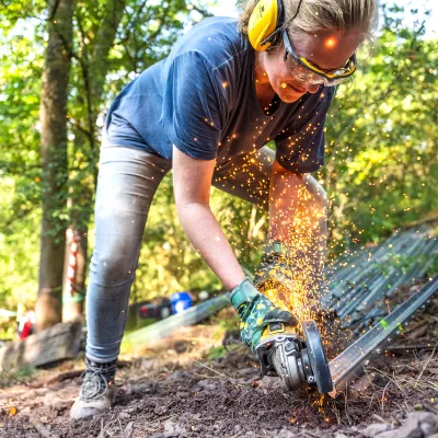 Teilnehmerin schneidet Metall, Funken sprühen