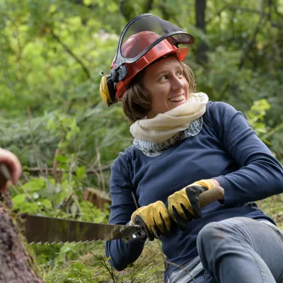 Junge Frau mit Zweimannsäge