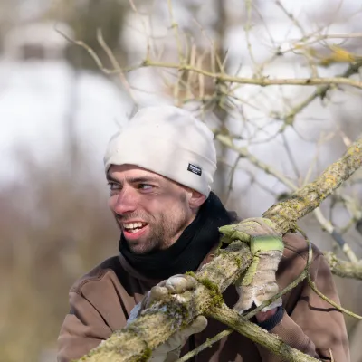 Mann mit Ast auf der Schulter