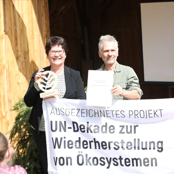 Sabine Riewenhermund Stephen Wehner bei der Übergabe der Urkunde zur Auszeichnung des Bergwaldprojekts als UN-Dekade.