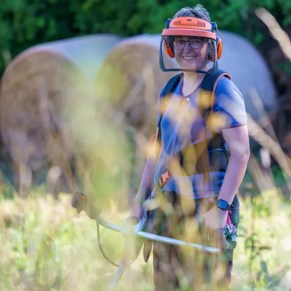 Eine Person in Schutzausrüstung auf einer Waldlichtung