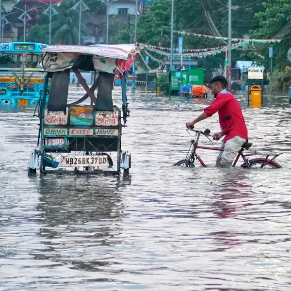 Mensch auf Fahrrad in einer überfluteten Stadt