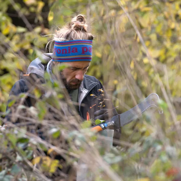 Person mit Gertel bei der Waldpflege