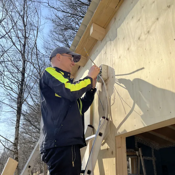 Person mit schraubt eine Schraube in Outdoor-Campküchen-Wand