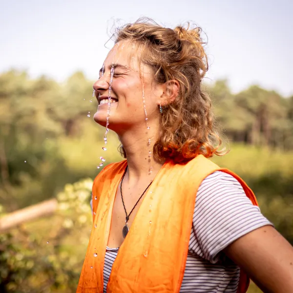 Frau im Wald mit Wasser im Gesicht