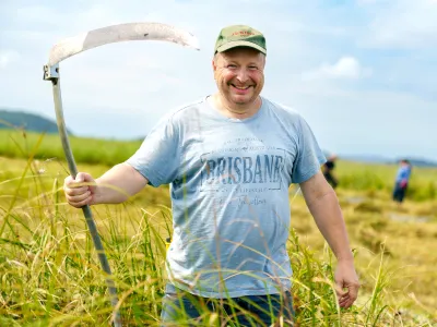 Lächelnder Teilnehmer mit einer Sense