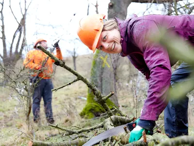 Lächelnde Frau mit Astsäge