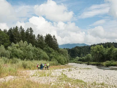 Menschen in der bewaldeten Flusslandschaft