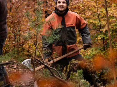 Junger Mann mit Regenkleidung und Wiedehopfhaue
